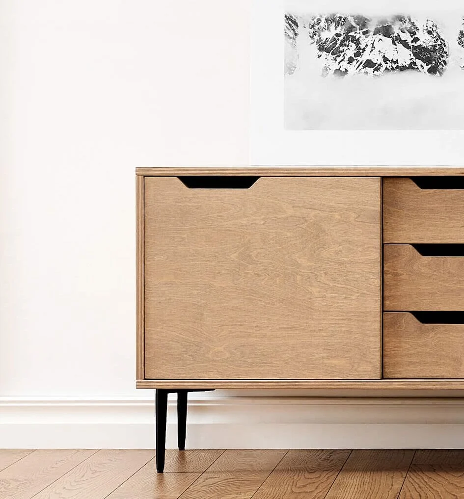 Dressoir Slaarmond 135 cm met houten look, zwarte poten en ruime lades in een rustige woonruimte
