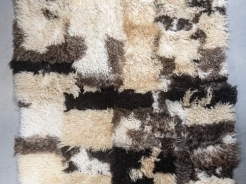 Schapenvacht Saansol 200x150 cm met krullende patchwork structuur in naturel, zwart en bruintinten