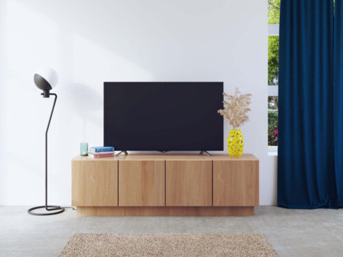 TV-meubel Nustesta Wit 145 cm met eikenfineer, vier deuren en warme houtlook in een rustige woonkamer