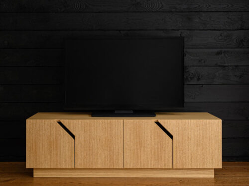 TV-meubel Prulto wit 145 cm met eikenfineer, vier deuren en diagonale details onder een tv.
