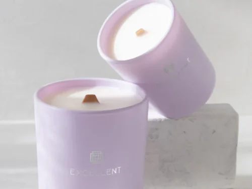 Paars Geurkaars Belvun in glas met witte was en houten lont op decoratieve stenen blokken