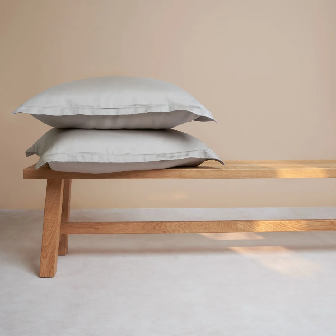 Kussenhoes Peelas taupe, zacht Tencel, 60x50 cm, op een houten bank in rustige woonstijl