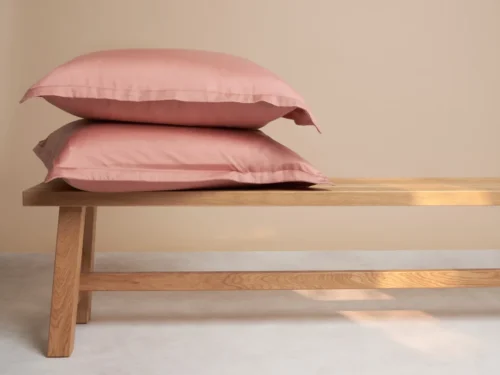Roze Sonang kussenhoes van Tencel met luxe satijnweving, zacht en ademend, afgebeeld op twee kussens.