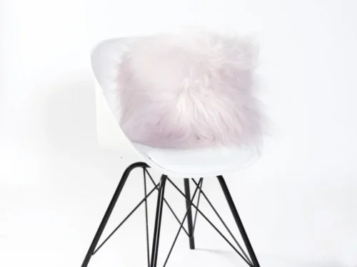 Schapenvacht Cernu lichtroze op witte stoel, zacht en fluffy woonaccessoire met warme uitstraling