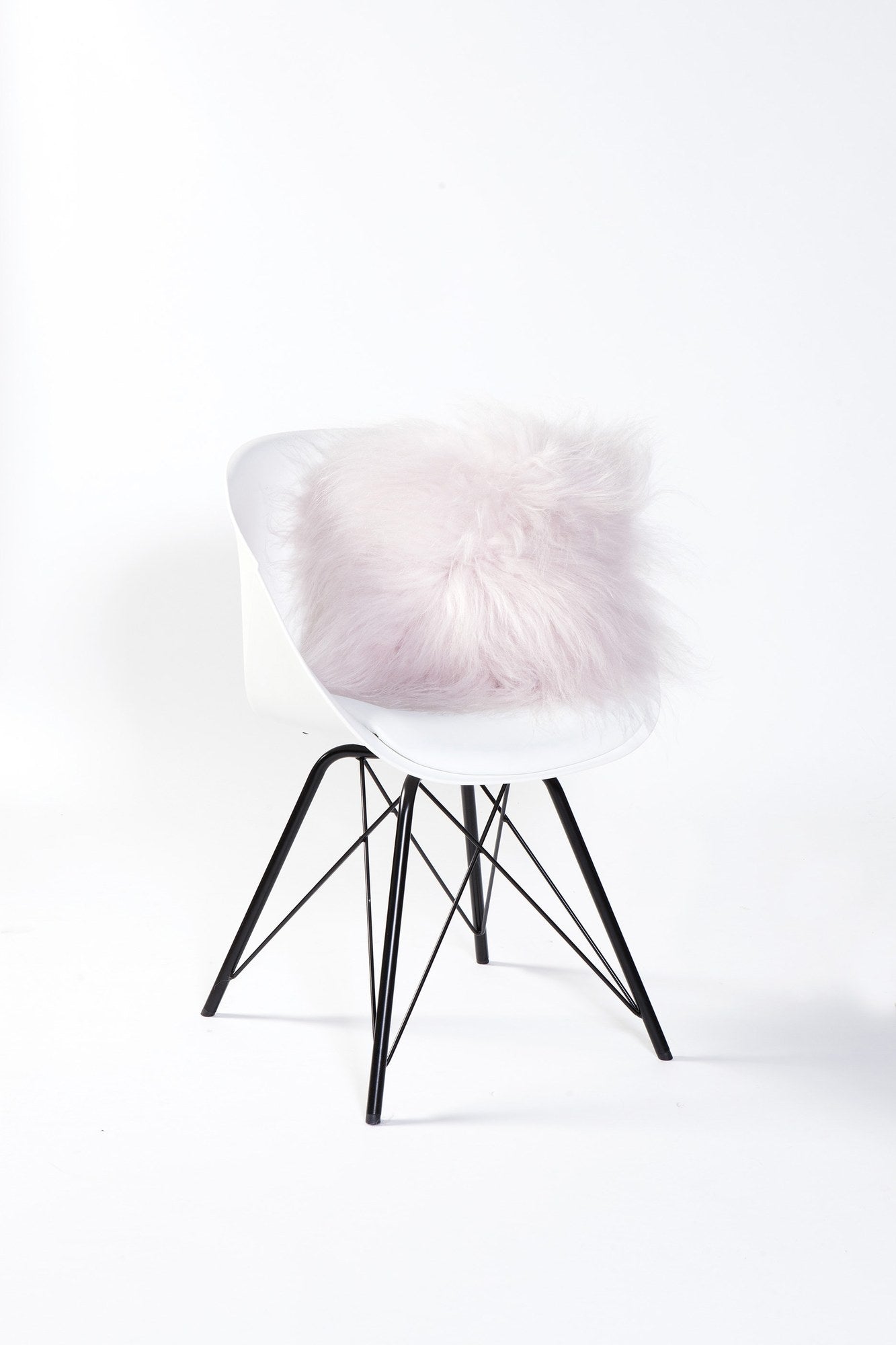 Schapenvacht Cernu lichtroze op witte stoel, zacht en fluffy woonaccessoire met warme uitstraling