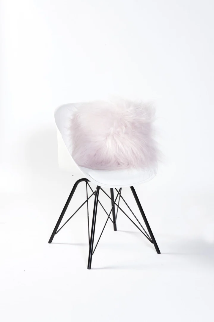 Schapenvacht Cernu lichtroze op witte stoel, zacht en fluffy woonaccessoire met warme uitstraling