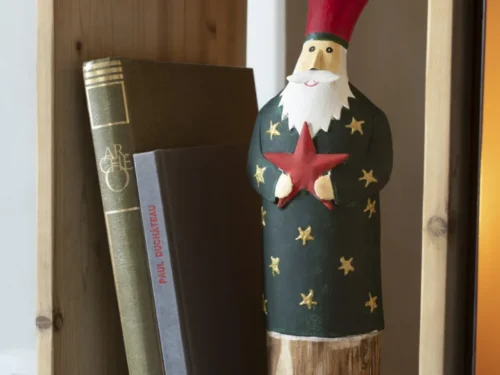 Skaultona kunstbloem in meerkleurig metaal en hout, decoratief op houten plank naast boeken
