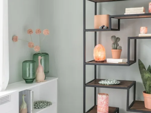 Vaas Rokek groen glas met ronde vorm, gevuld met droogbloemen op een witte kast in een rustige woonruimte