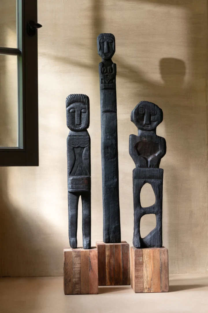 Beeld Raalvine van zwart gerecycled hout op blok, met drie slanke abstracte figuren, H160 cm