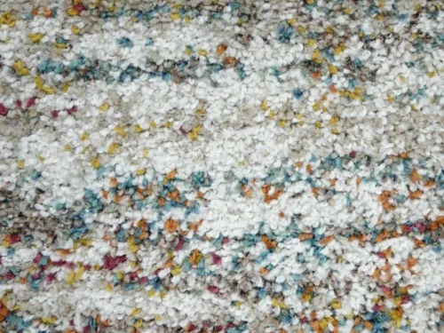 Vloerkleed Vaussora met zachte pool, volle structuur en speelse multicolor accenten in rustige tinten
