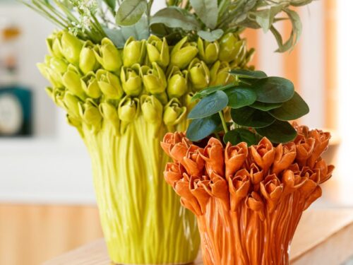 Vaas Heltang Steen Oranje H19 cm met oranje glazuur en ronde vorm, gevuld met kunstbloemen op houten tafel
