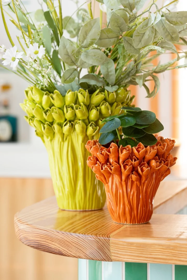 Vaas Heltang Steen Oranje H19 cm met oranje glazuur en ronde vorm, gevuld met kunstbloemen op houten tafel