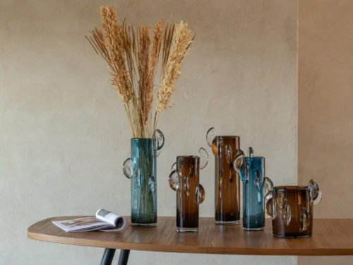 Vaas Soke Glas Bruin met strakke cilinder vorm en decoratieve glazen oren op een houten tafel