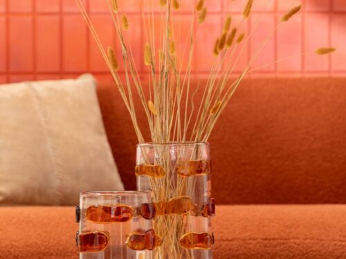 Vaas Tieldos glas meerkleurig H23 cm met amber accenten, gevuld met droogbloemen op een houten tafel