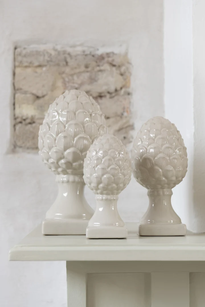 Beikura porseleinen dennenappel op voet in beige, glanzend en decoratief woonaccessoire in compact formaat