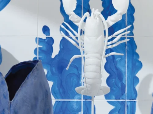 Witte kreeftvormige vaas op standaard voor blauw getegelde wand, met organische armen en scharen