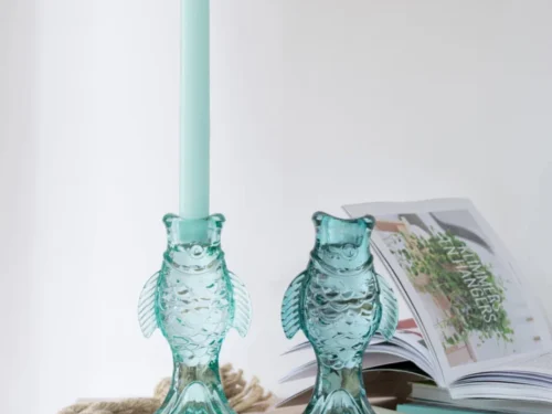 Opbergdoos Rondu Blauw: blauwe visvormige kaarsenhouders met brandende tafelkaars en rustige styling
