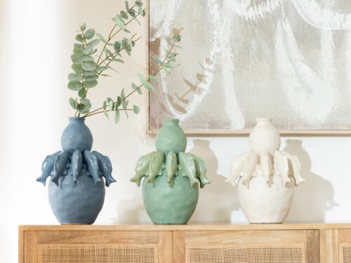 Vaas Jaldia porselein blauw met visvorm, gevuld met takken op een houten dressoir