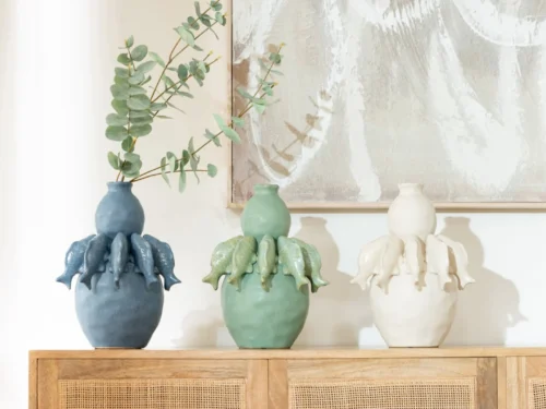 Vaas Jaldia porselein blauw met visvorm, gevuld met takken op een houten dressoir