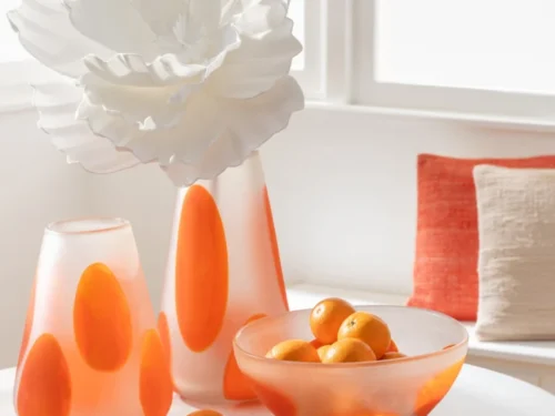 Kom Gruna Glas Oranje schaal met transparante oranje accenten, gevuld met sinaasappels op tafel