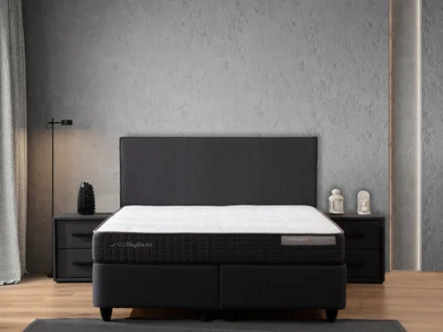 Nachtkastje Slilto in zwart, strak design met lade voor een moderne slaapkamer naast het bed