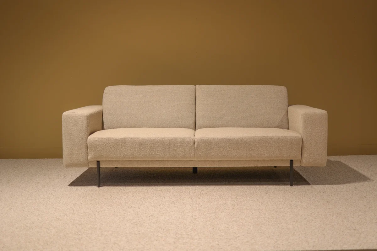 Bank Jiso Zwart, moderne 2-zitsbank met beige stof, strakke lijnen en slanke zwarte poten
