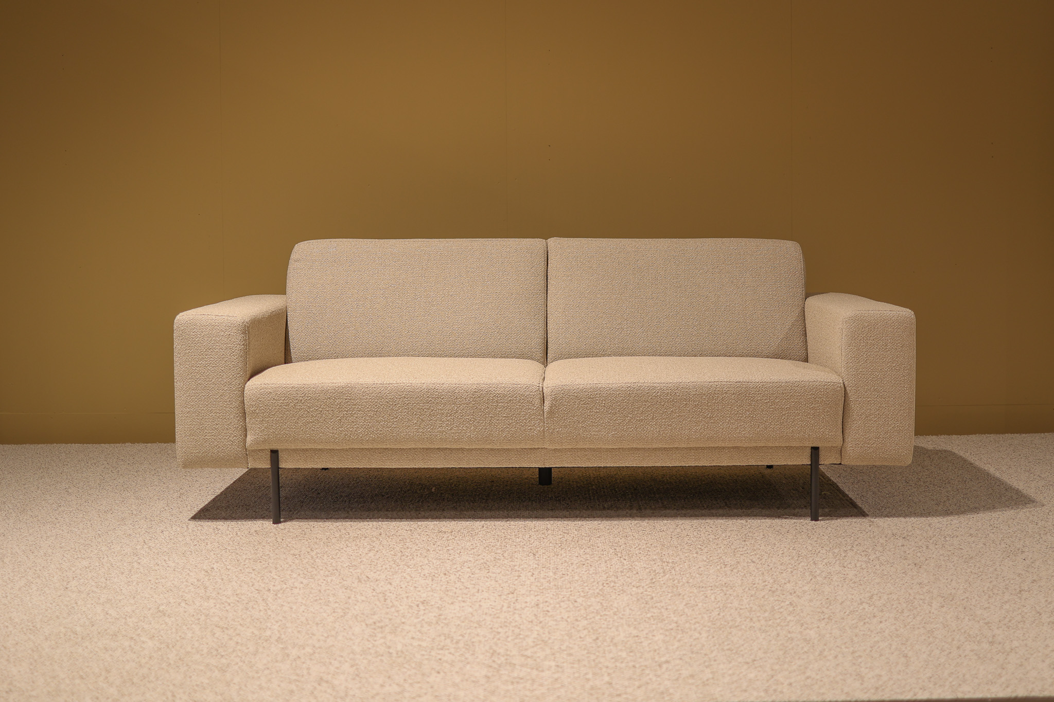 Bank Jiso Zwart, moderne 2-zitsbank met beige stof, strakke lijnen en slanke zwarte poten