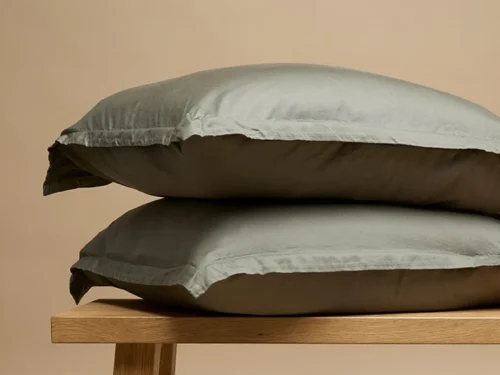 Kussenhoes Pietar 65x65 cm in keperlook, rustig grijs, met volle, zachte vorm op houten bankje