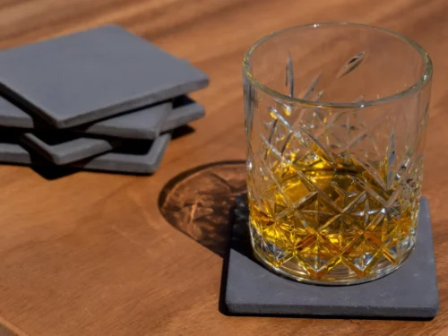 Onderzetter Brolil Beton set van 3, handgemaakte betongrijze coasters onder een glas op houten tafel