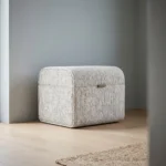 Poef Eldarsiena van Domkapa met licht gestreepte bekleding, afgeronde vorm en compact ontwerp