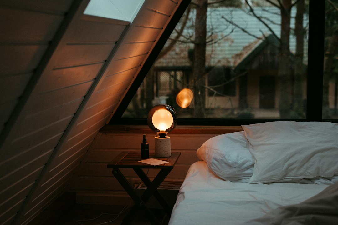 Lichte slaapkamer met bed onder het raam en een nachtkastje