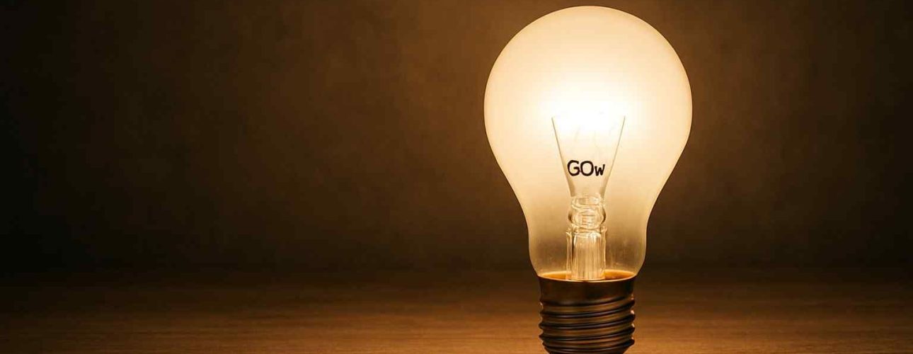 Gloeiende lamp op houten tafel, zacht licht. De lamp heeft het opschrift GOW. Sfeervolle verlichting voor een comfortabele woonkamer.