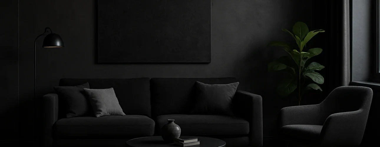 Een moderne woonkamer met donkere muren en meubels, waaronder een zwarte bank die de psychologie van de kleur zwart weerspiegelt (Wat is de psychologie van de kleur zwart), fauteuil, ronde salontafel, potplant en een leeg canvas. Zachte verlichting creëert een stemmige, minimalistische sfeer.