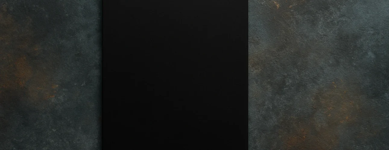 Een effen zwart rechthoekig vel papier, dat duidelijk laat zien welke kleur zwart absorbeert, is gecentreerd op een gestructureerd donkergrijs en bruin oppervlak, van bovenaf gezien. Het ongemarkeerde papier steekt af tegen de gevlekte achtergrond.