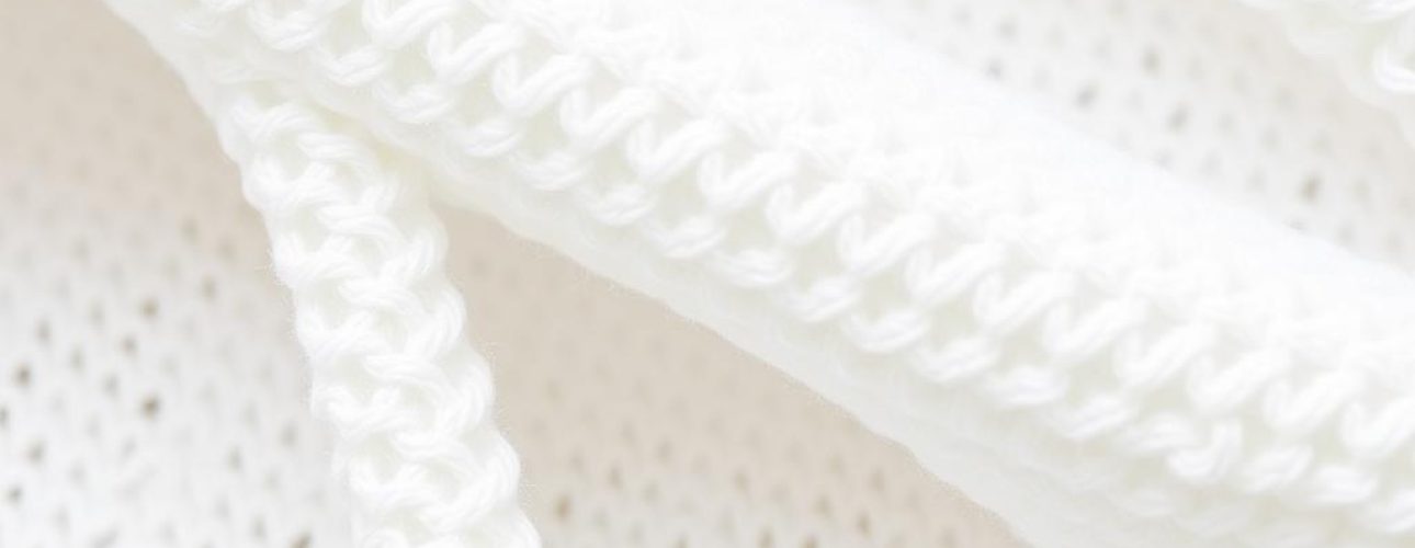 Close-up van witte boucle stof met zichtbare lusjes en textuur.